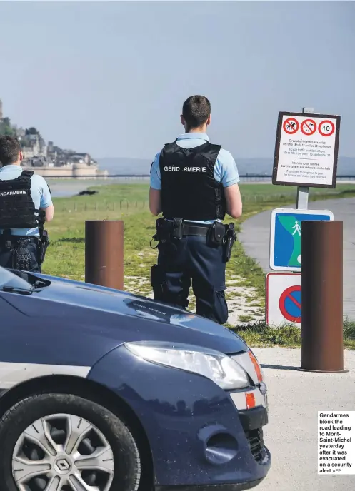  ?? AFP ?? Gendarmes block the road leading to MontSaint-Michel yesterday after it was evacuated on a security alert