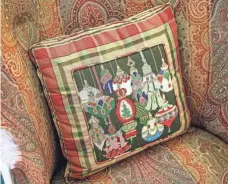  ?? ?? This pillow in the living room has a needlepoin­t insert with a Christmas theme.