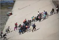  ??  ?? Migrants move toward the border fence in Tijuana.