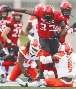  ?? The Canadian Press ?? B.C. Lions defender T.J. Lee, right, tries to bring down Calgary Stampeders running back Jerome Messam during CFL action in Calgary on Saturday.
