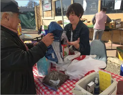  ?? RICH FREEDMAN — TIMES-HERALD ?? Moira Farrell of Outpaw Outreach sets up a pop-up table at Faith Food Fridays, handing out food and jackets for dogs and cats in need.