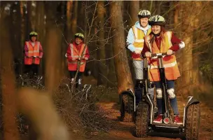  ??  ?? Riding through the woods on Segways