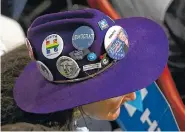  ??  ?? A delegate is decked out with Hillary Clinton pins on the second day of the Democratic National Convention.