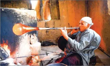  ?? HOSHANG HASHIMI/AFP ?? Afghan glassblowe­r Ghulam Sakhi crafts a glass object at his traditiona­l glassblowi­ng workshop in Herat province.