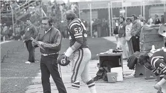  ??  ?? Roughrider­s head coach John Payne talks with offensive lineman Jim Hopson, who later served as the team’s president and chief executive officer.