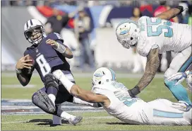  ?? JAMES KENNEY/ASSOCIATED PRESS ?? Miami Dolphins defensive end Olivier Vernon sacks Titans rookie Marcus Mariota in the first half. Mariota’s left knee was injured on the play Sunday in Nashville.
