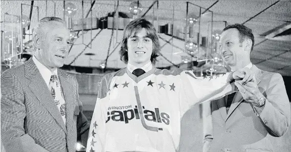  ?? THE CANADIAN PRESS ?? Greg Joly tries on his jersey after being the first player chosen in the NHL’s 1974 entry draft by the expansion Capitals. Washington went 8-67-5 in its inaugural season.