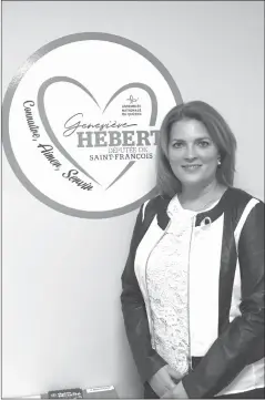  ?? EMILIE HACKETT ?? Geneviève Hébert poses next to her logo in her King Street East office.