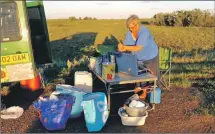  ??  ?? Anne cooks dinner at the roadside during their marathon rally.