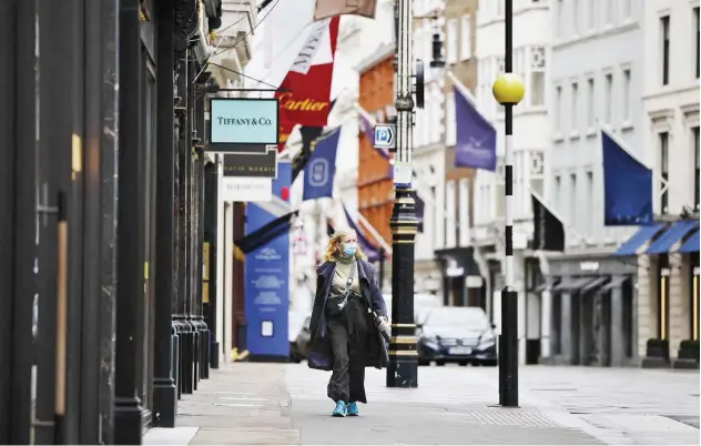  ?? Agence France-presse ?? ↑
A pedestrian passes by closed shops in the Mayfair area of central London on Thursday.