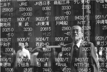  ??  ?? A pedestrian is reflected in an electronic stock board outside a securities firm in Tokyo on Oct 18. — WP-Bloomberg photo