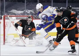  ?? DERIK HAMILTON — THE ASSOCIATED PRESS ?? Flyers goalie Carter Hart, left, manages a save past the screen of Buffalo Sabres’ Tage Thompson, center and Flyers defender Justin Braun during the second period Sunday at Wells Fargo Center.