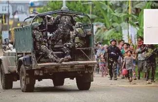  ?? AGENCIES PIX ?? Philippine troops escorting civilians while a military truck covers them from sniper fire in a village in Marawi on Wednesday.
(Inset) An attack helicopter firing rockets at militants on Wednesday.