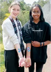  ?? ?? Locals Vanessa McDonald (left) and Maithya Armour opt for arm art instead of face painting.