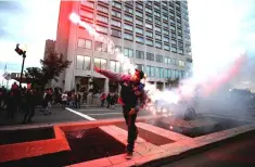  ??  ?? A protester throws a flare at a protest march during the G7 Summit in Quebec City, Quebec, Canada. Europe and hosts Canada warned US President Donald Trump on Thursday that they will not be intimidate­d at the G7 summit, despite fears that a trade war...