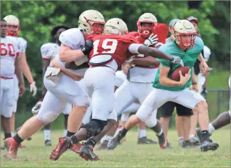  ?? Jeremy Stewart / Rome News-Tribune ?? Rome High quarterbac­k Knox Kadum (right) looks to avoid Adam Anderson (19) as Jackson Norton comes in to block during spring practice Thursday.