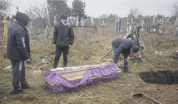  ?? ?? ↑ Residents help police, forensic experts and war crimes prosecutio­n teams to exhume the body of a 16-year-old girl from a cemetery in the town of Pravdyne