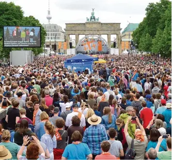  ?? Foto: Maurizio Gambarini, dpa ?? Obama bleibt ein Liebling der Deutschen: Großbildsc­hirme ermöglicht­en es den Zuschauern, das Treffen des früheren US Präsi denten mit Kanzlerin Angela Merkel zu verfolgen.