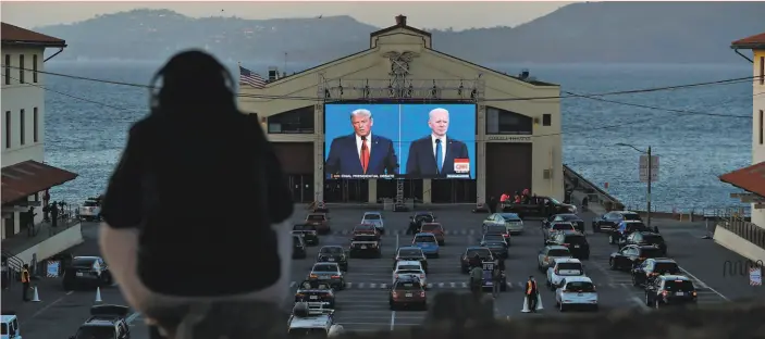  ?? Scott Strazzante / The Chronicle ?? People watch President Trump and former Vice President Joe Biden in the final presidenti­al debate on a video screen at Fort Mason in San Francisco in October.