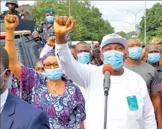  ??  ?? Enugu State Governor, Ifeanyi Ugwuanyi ( right) and his deputy, Mrs. Cecilia Ezeilo, acknowledg­ing cheers from protesters led by Flavour and Phyno, during the Enugu # ENDSARS protest, at the Government House, Enugu… yesterday.
