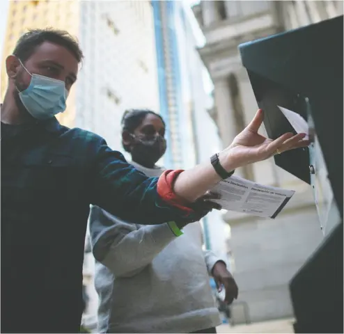  ?? MARK MAKELA / GETTY IMAGES ?? Philadelph­ia voters cast their early voting ballot last week at a drop box outside of city hall.