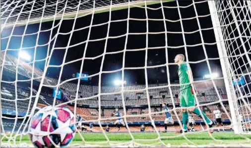  ??  ?? Cillessen se lamenta, tras recibir un gol el martes, mientras los jugadores del Atalanta lo celebran, en un estadio vacío.