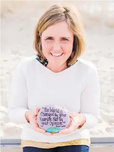  ??  ?? Megan Murphy paints positive messages on rocks for strangers to find.