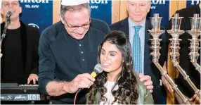  ?? (Variety Israel) ?? VARIETY ISRAEL chairman Ori Slonim holds the microphone for singer Eden Taharany at last week’s Tel Aviv Hilton Hanukka party.