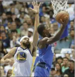  ?? PHOTO/LM OTERO ?? Dallas Mavericks forward Harrison Barnes (right) drives against Golden State Warriors center JaVale McGee (left) during the first half of an NBA basketball game in Dallas on Monday. AP