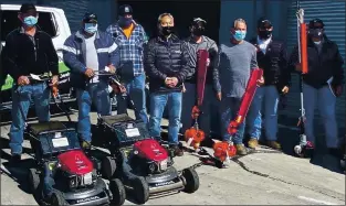  ?? SAN JOSE POLICE DEPARTMENT ?? Richard Ogawa, center, of Campbell, the CEO of Gardenland Power Equipment, is seen with landscaper­s at a San Jose police warehouse in San Jose on March 23.