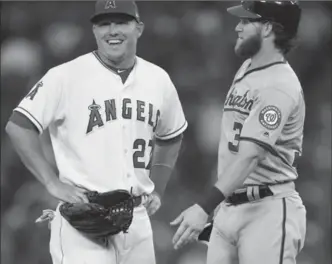  ?? LOS ANGELES TIMES FILE PHOTO ?? Los Angeles Angels’ Mike Trout, left, and Bryce Harper of the Washington Nationals chat at second base in Anaheim, Calif., in July. Coincidenc­es keep piling up for the often compared superstars.