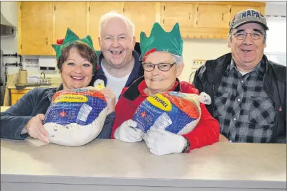  ?? ERIC MCCARTHY/JOURNAL PIONEER ?? Getting in the Christmas spirit as they prepare for the eighth annual Christmas Day meal are, Judy Peters, left; John and Jean Hagen, and Preston Murphy. Volunteers are welcome to join them at St. Anthony’s Hall in Woodstock on Christmas Eve as they...