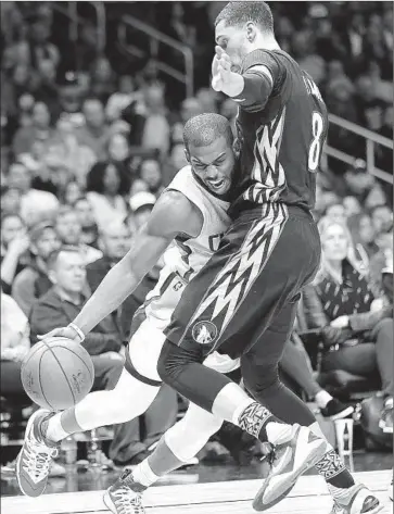  ?? Robert Gauthier
Los Angeles Times ?? MINNESOTA’S Zach LaVine stands firm against hard-driving Chris Paul late in the game at Staples Center.