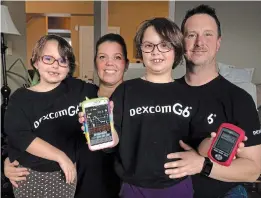  ?? PAUL FORSYTH TORSTAR ?? Ava Everson, shown with little sister Eliana, left, mom Kari and dad Jason, holds her smartphone showing a graph tracking her blood glucose levels, which are continuall­y monitored by a device she wears.