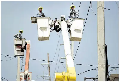  ?? AP file photo ?? Workers for Puerto Rico’s Electric Power Authority in October repair distributi­on lines damaged by Hurricane Maria in the Cantera community of San Juan.