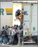  ??  ?? Migrants board a truck on way to Calais