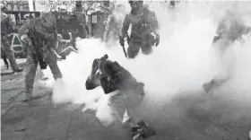  ?? NOAH BERGER/AP ?? Federal officers use chemical irritants and crowd control munitions to disperse protesters Wednesday in Portland, Ore.