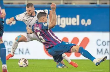  ?? ?? Juan Berrocal se va al suelo para intentar frenar a Luis Rioja, en el partido de ayer en Ipurua.