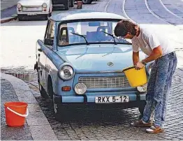  ?? Foto: Rainer Kitte ?? Das liebte der DDR-Autofahrer: Am Wochenende wurde eingeschäu­mt und abgespritz­t, und wer für die Sauberkeit seines Trabis keinen Schlauch nutzen konnte, trug Wassereime­r auf die Straße. Wie es heute ist, steht im Kapitel „Waschzwang“.