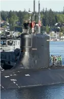  ?? ?? Submariner­s standing on top of the USS Connecticu­t in the water at Naval Base Kitsap