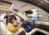  ?? Bloomberg/QILAI SHEN ?? Customers look inside a NIO Inc. ES8 sport utility vehicle on display earlier this month at the Nio House showroom at the Shanghai Tower in Shanghai, China.