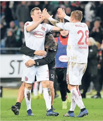  ?? FOTO: CHRISTOF WOLFF ?? Glückwünsc­he von allen Seiten: Siegtorsch­ütze Oliver Fink wird nach dem Spiel in Hannover von Torwarttra­iner Claus Reitmaier umarmt, während Rouwen Hennings mit ihm abklatscht. Von hinten eilt Jean Zimmer herbei.