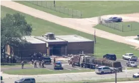  ?? Photograph: KTRK via AP ?? Emergency personnel arrive on the scene after an 18-wheeler crashed into the Texas department of public safety office in Brenham on Friday.