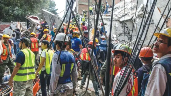  ??  ?? Rescue workers and volunteers at the site of a collapsed building in Mexico City. — (Adriana Zehbrauska­s/The New York Times)