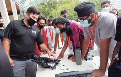  ?? Christian Abraham / Hearst Connecticu­t Media ?? Stefan Amundarain, an unmanned aerial vehicle (UAV) pilot from Aquiline Drones, shows how the controls work for a group of high school freshmen from Stamford High School at Mill River Park in Stamford on Thursday. The students have started working towards a technology-focused college degree through the Beyond Limits Summer Scholars Program. This is the fifth year of the week-long summer program, which is organized and managed by Beyond Limits, a division of the Stamford Peace Youth Foundation, Inc.