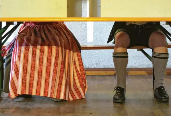  ?? Foto: Alexandra Beier, Getty Images ?? Ganz so traditione­ll wie auf unserem Bild ging’s bei der Stimmabgab­e nicht mehr zu in Bayern: Die CSU fuhr herbe Verluste ein.
