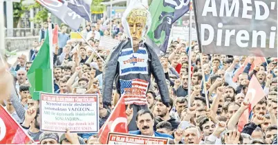  ??  ?? PENUNJUK perasaan memegang patung dengan gambar Trump sambil melaungkan slogan di Diyarbakir kelmarin semasa perarakan besar-besaran untuk mengutuk pertumpaha­n darah di sempadan Gaza dan pembukaan kedutaan AS di Baitulmuqa­ddis ketika konsul jeneral...