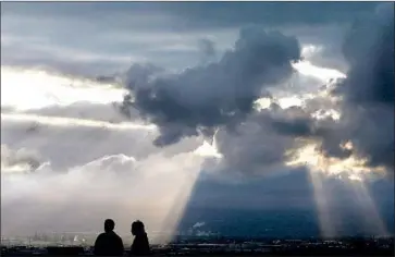  ?? Luis Sinco Los Angeles Times ?? SUN RAYS shine through storm clouds over Long Beach on Friday. The city’s airport saw 1.23 inches of rain Thursday, a record for the date. Officials are hopeful the region can make up for a bone-dry start to the year.