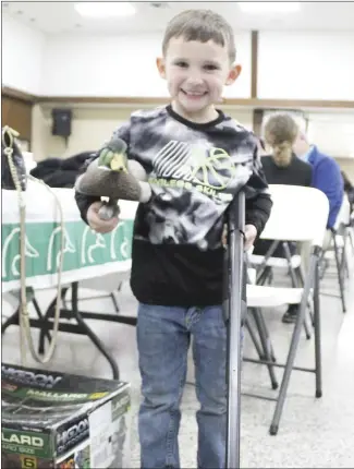  ?? Katie West • Times-Herald ?? First-time attendee Paxton Carlisle holds up a decoy and gun he won during the 2021 Ducks Unlimited Membership Banquet held Friday at the Forrest City Civic Center. The decoy was part of a set he won at the auction held to raise funding for wetland conservati­on, while the gun was won through a drawing. He is the grandson of Peggie Cartillar, who was one of several members at the event to be awarded Lifetime Membership­s for contributi­ons over $10,000.