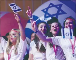  ?? (Marc Israel Sellem/The Jerusalem Post) ?? BIRTHRIGHT PARTICIPAN­TS wave flags and cheer during an event in Jerusalem. The author says that a healthy Israel-Diaspora relationsh­ip requires Israeli self-reflection, responsibi­lity and creativity.